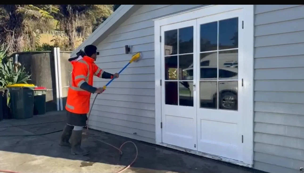 Ariana Cleaning team member washing an Auckland house exterior
